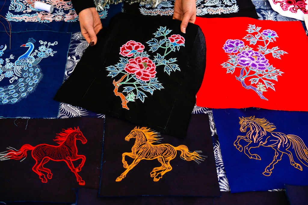 3月7日，绣娘在贵州省三都水族自治县“村马”比赛现场展示马尾绣。