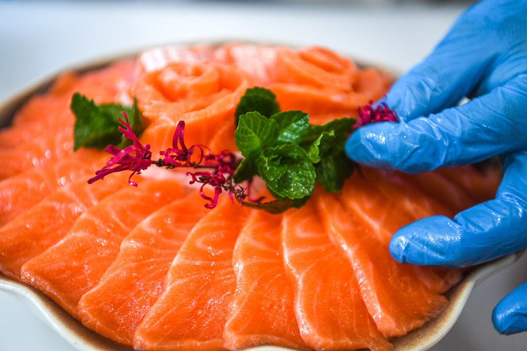 3月10日,工人在贵州省岑巩县淡水渔业基地将三文鱼切片摆盘。