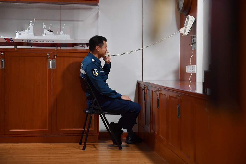 3月8日，海警三都舰执法员在休息时间与家人通话。新华社记者 毛俊 摄