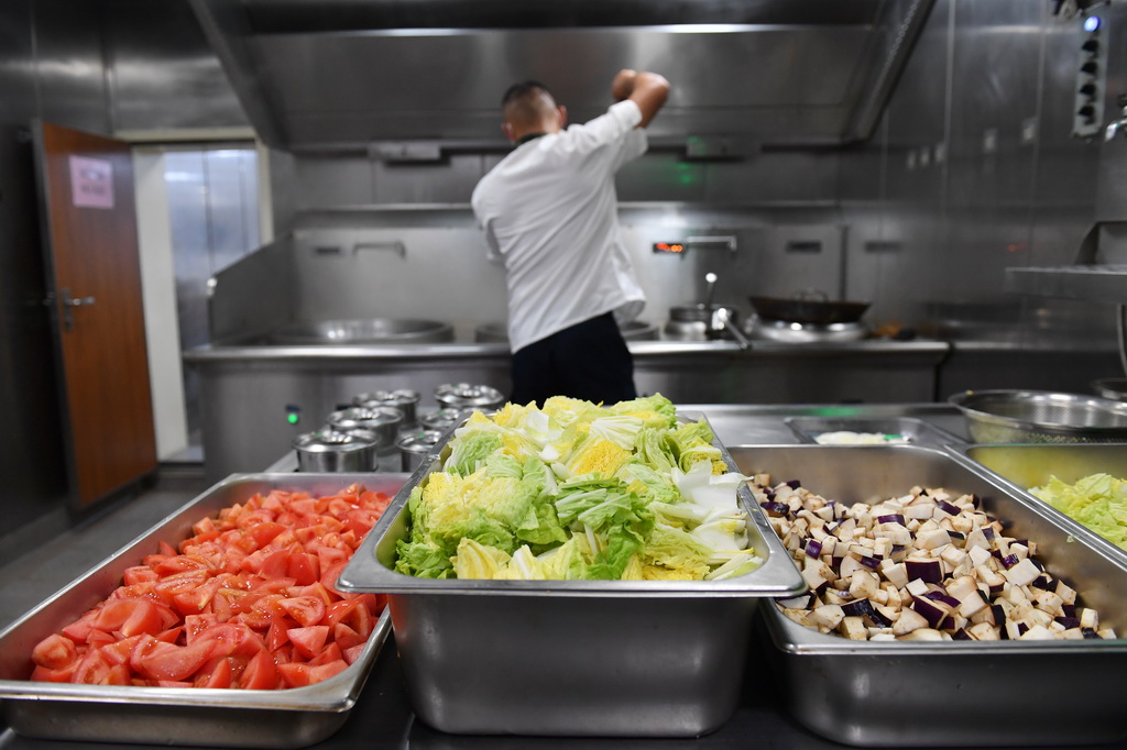 3月8日，海警三都舰执法员在烹饪晚餐。新华社记者 毛俊 摄