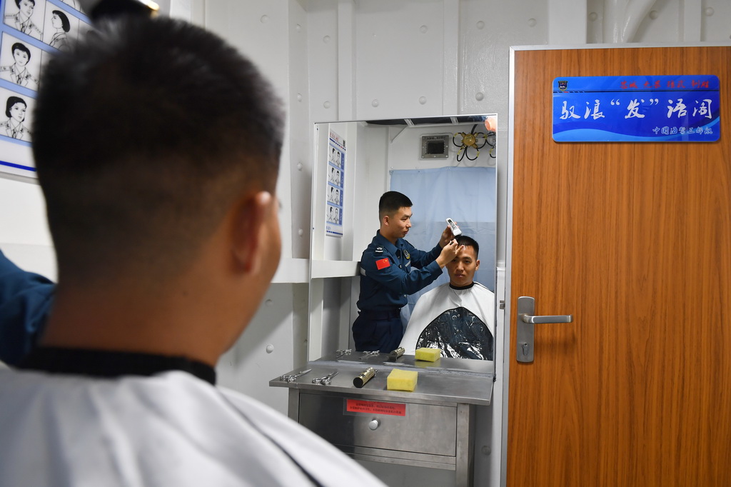 3月8日，海警三都舰执法员在理发。新华社记者 毛俊 摄