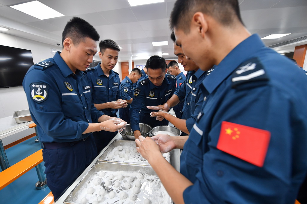 3月2日，海警三都舰执法员在舰内食堂包汤圆。新华社记者 毛俊 摄