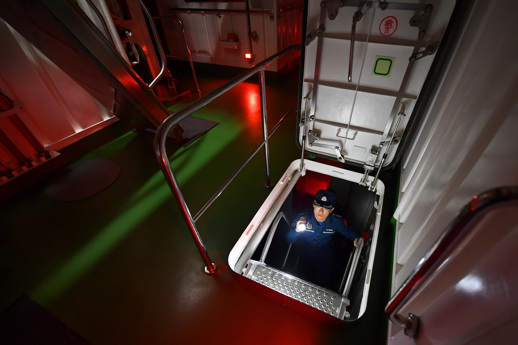 3月8日，海警三都舰执法员在巡舱检查。新华社记者 毛俊 摄