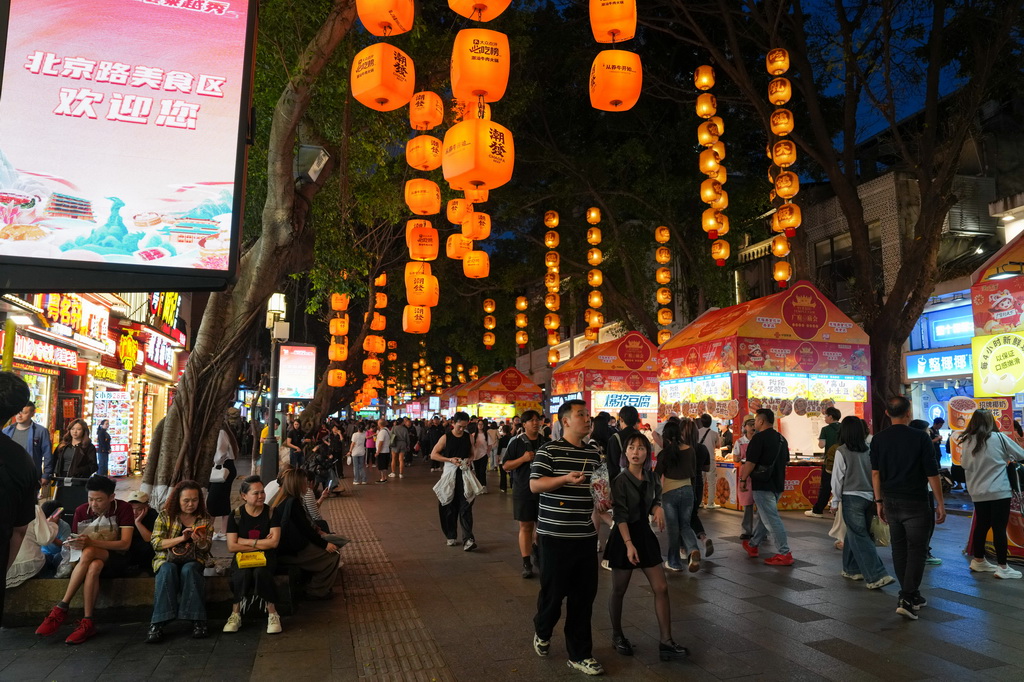 3月12日,在广州市越秀区北京路步行街区举办的美食庙会上,市民、游客在品尝美食。