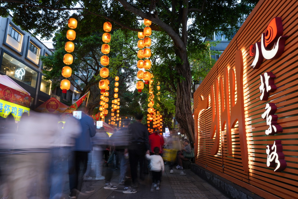 3月12日，在广州市越秀区北京路步行街区举办的美食庙会上，市民、游客在品尝美食。