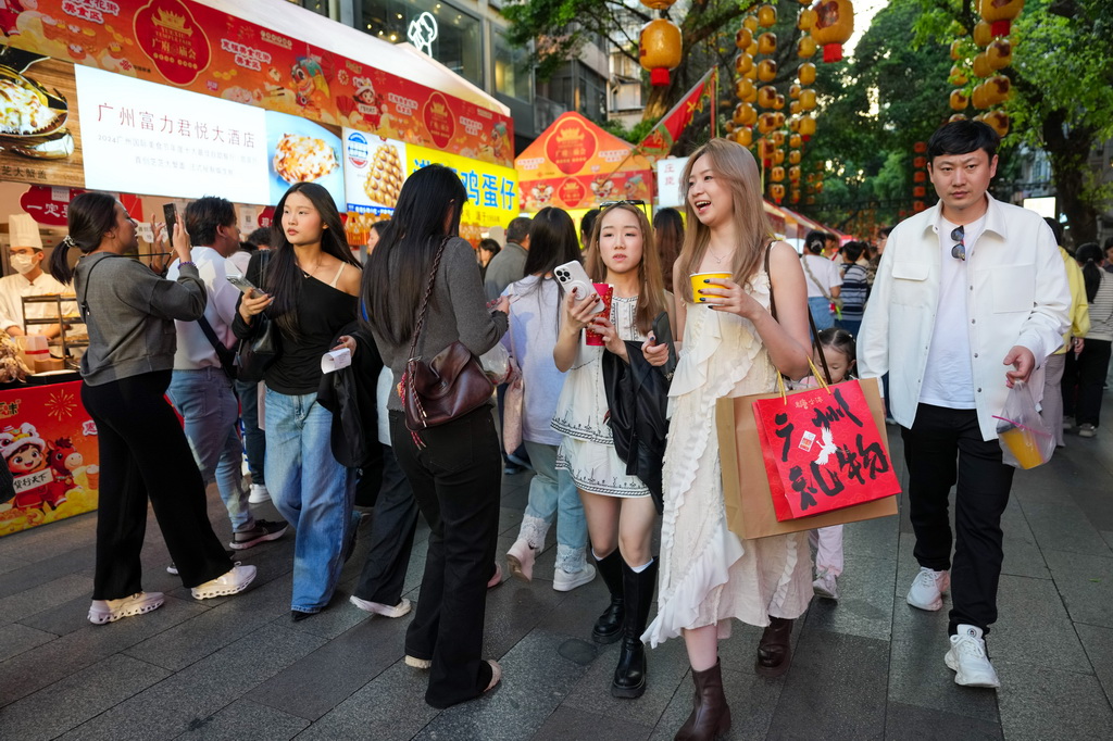 3月12日，在广州市越秀区北京路步行街区举办的美食庙会上，市民、游客在品尝美食。