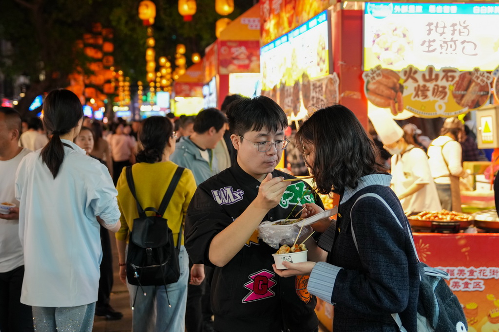 3月12日，在广州市越秀区北京路步行街区举办的美食庙会上，市民、游客在品尝美食。