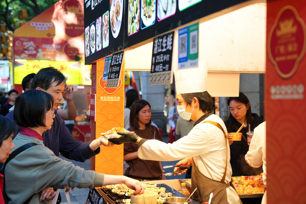 3月12日，在广州市越秀区北京路步行街区举办的美食庙会上，市民、游客在品尝美食。