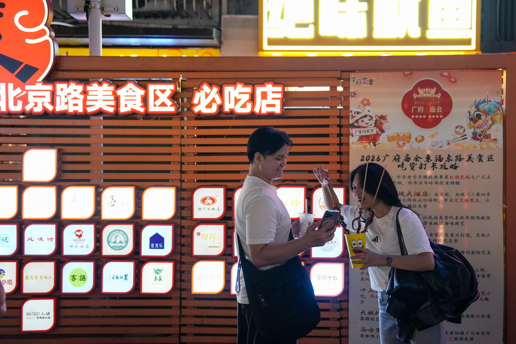 3月12日，在广州市越秀区北京路步行街区举办的美食庙会上，市民、游客在品尝美食。