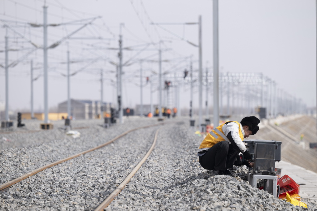 3月13日，工人在哈伊高铁绥化南站施工现场安装信号设备。