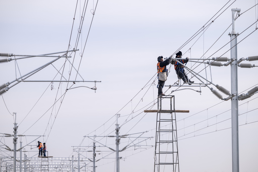 3月13日,工人在哈伊高铁绥化南站施工现场进行接触网作业。