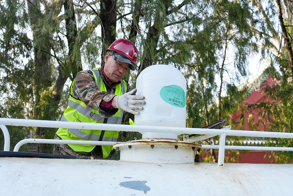 3月15日，在北京地坛公园，工作人员在向洒水车内添加花粉控制剂。