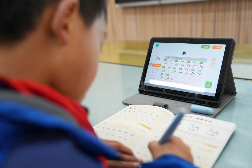 3月17日，学生在湖南湘江新区雷锋小学使用AI练字笔上书写课。他们的一笔一画会实时同步至平板终端，系统会从笔画顺序、笔画数量、间架结构等10个维度自动评测，生成个性化书写报告，帮助学生养成良好的书写习惯。