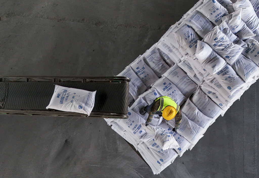 3月17日，工人在位于绥化市的哈尔滨铁路物流中心绥化营业部农资装卸作业现场卸化肥（无人机照片）。