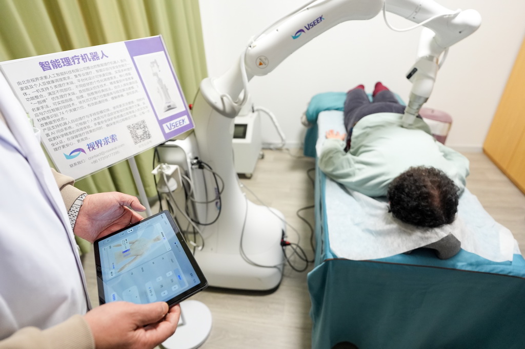 在智慧康养机器人养老驿站内，一名社区居民体验一款智能理疗机器人（3月18日摄）。