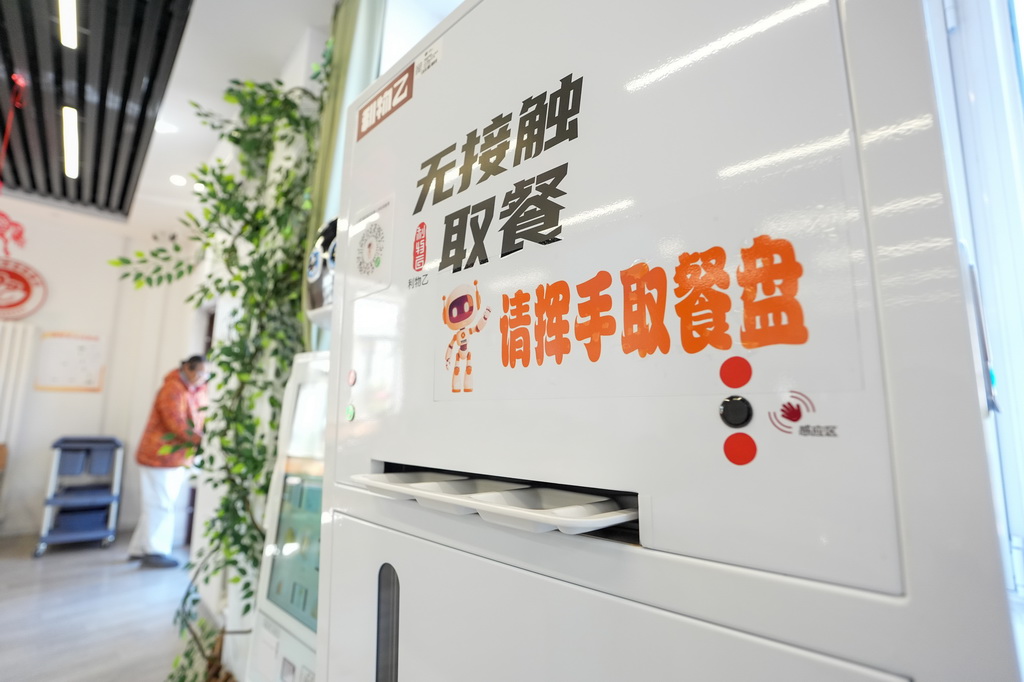 北京荣华街道智慧康养机器人养老驿站内的智能分餐盘机（3月18日摄）。