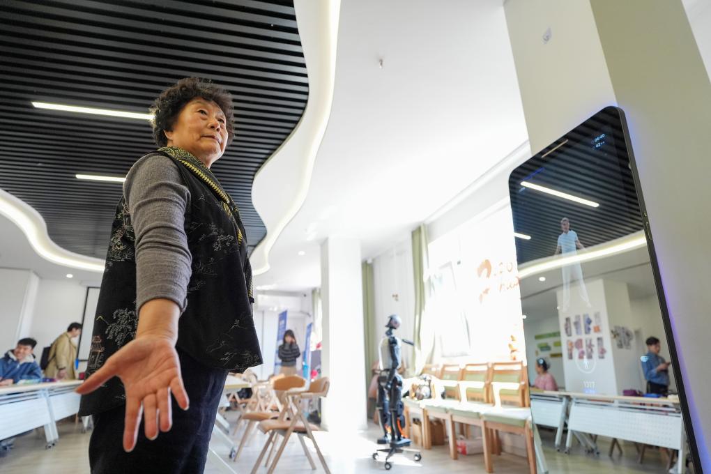 在智慧康养机器人养老驿站内，一名社区居民跟随一款智能设备练习八段锦（3月18日摄）。