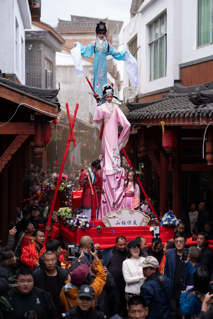 3月20日，四川省兴文县九丝城镇建武村，演员在巡游活动中表演木台铁桩戏《山伯访友》。