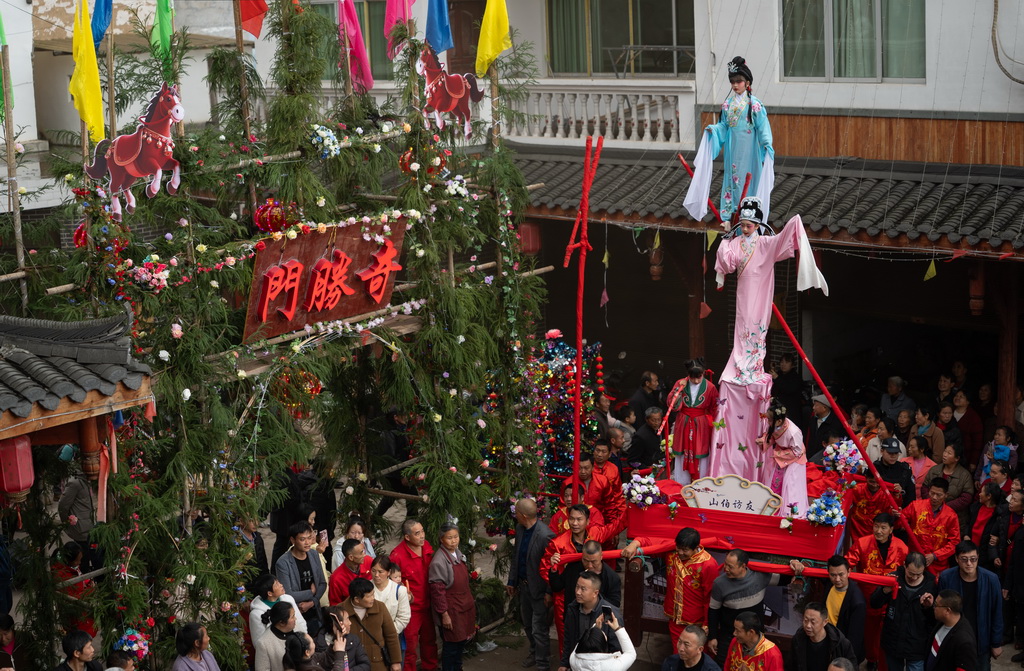 3月20日，四川省兴文县九丝城镇建武村，演员在巡游活动中表演木台铁桩戏《山伯访友》。