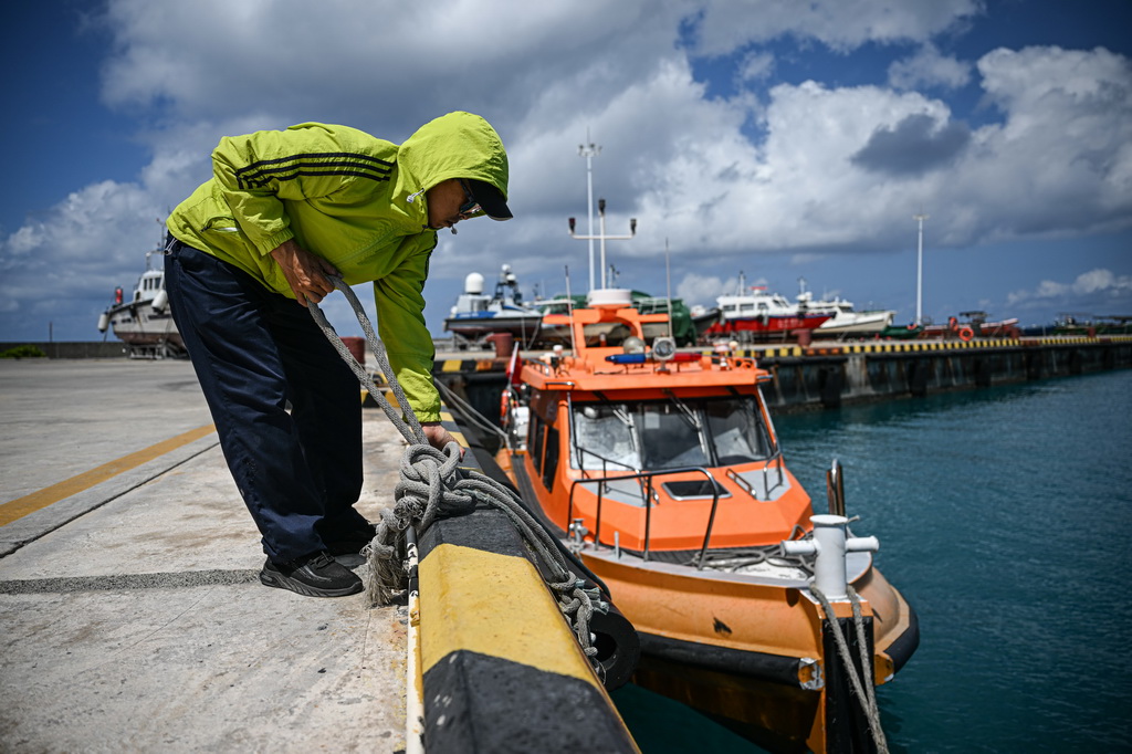 3月19日，在海上交通保障船抵达海南三沙永兴岛码头后，工作人员整理缆绳准备固定船只。新华社记者 蒲晓旭 摄