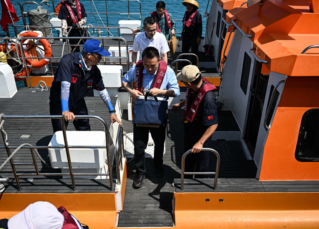 3月20日，在乘坐海上交通保障船由海南三沙赵述岛抵达永兴岛后，乘客有序下船。新华社记者 刘莲芬 摄