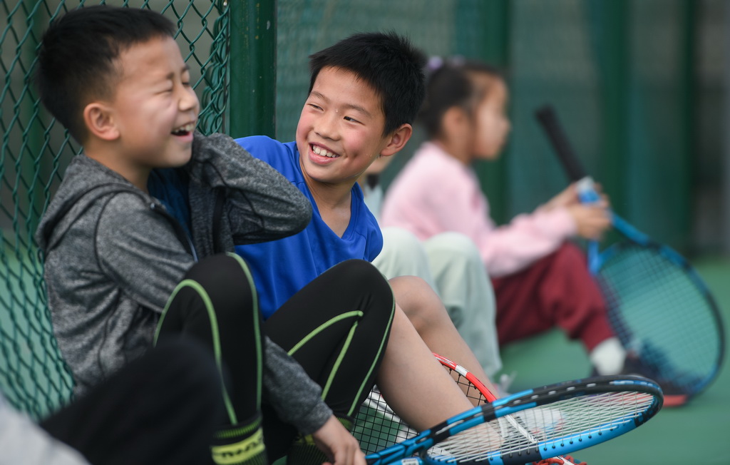 小朋友在湖北省京山市文峰公园网球场休息玩耍(2024年3月22日摄)。新华社记者 杜子璇 摄