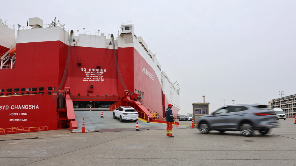 3月24日,工作人员在码头引导国产新能源汽车驶入汽车滚装船。