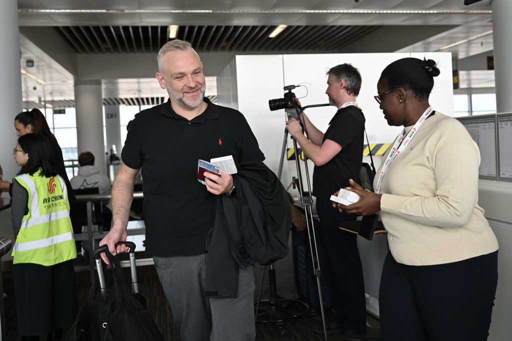 3月24日,在比利时布鲁塞尔国际机场,搭乘首航航班的乘客准备登机。