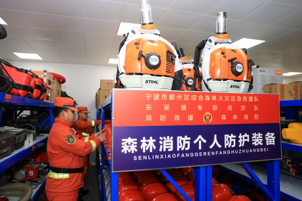 3月24日,在浙江省宁波市鄞州区东吴镇驻地的执勤器材库内,当地综合森林火灾应急救援队队员检查森林消防个人防护装备情况。新华社记者 江汉 摄