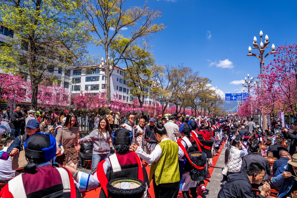 3月26日,人们在丽江市雪山路长街宴活动现场打跳。