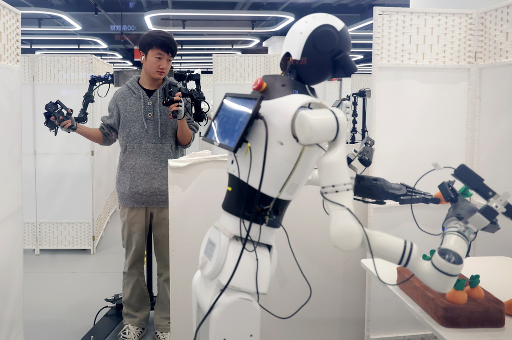 3月25日，在北京市石景山区首钢园内的人形机器人数据训练中心，工作人员在训练机器人。新华社记者 张晨霖 摄