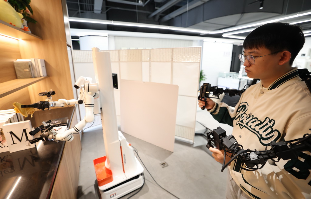 3月25日，在北京市石景山区首钢园内的人形机器人数据训练中心，工作人员在训练机器人。