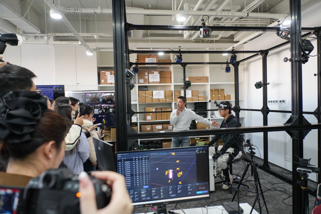 3月18日，在北京中关村（海淀）具身智能创新产业园，诺亦腾机器人副总裁、合伙人李遥（后排右二）在介绍高精度人类行为数据与机器人数据的采集、标注、预处理。新华社记者 谢晗 摄
