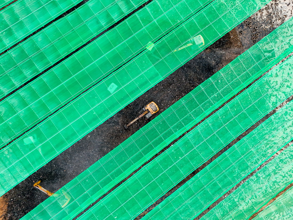 在玉龙垃圾填埋场环境修复工程现场，机械设备在巨型天幕下进行开挖作业（1月30日摄）。新华社记者 梁旭 摄