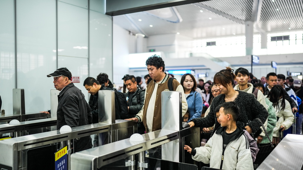 4月1日,旅客在六盘水火车站南站房排队验票乘车。
