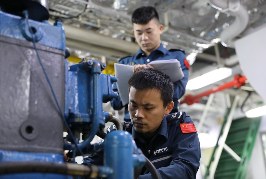 3月12日,中国海警万山舰执法员在机舱检修设备。