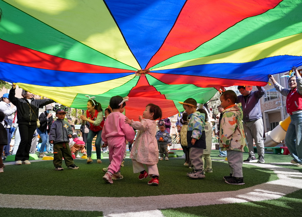 4月1日，在北京市第五幼儿园亲子托育活动现场，家长和孩子在老师引导下参加户外活动。