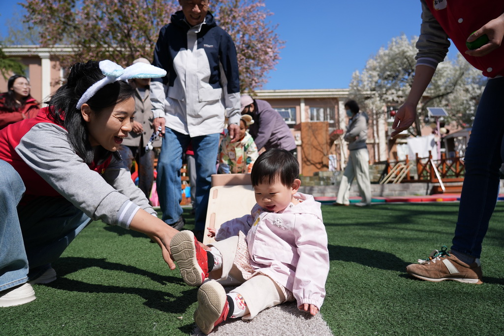 4月1日，在北京市第五幼儿园亲子托育活动现场，家长和孩子在老师引导下参加户外活动。