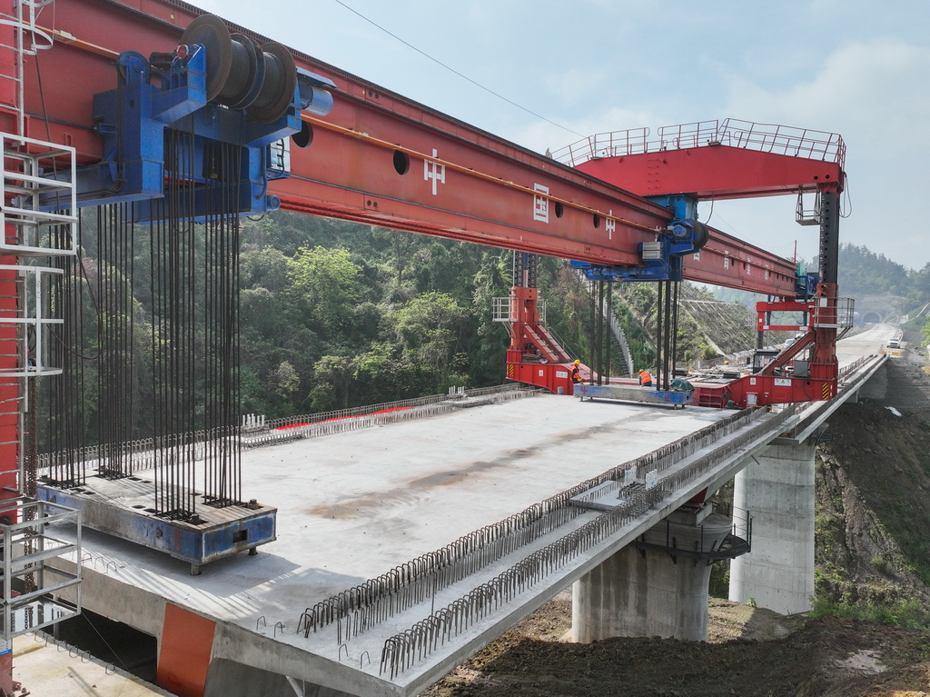 4月3日在四川省达州市拍摄的西渝高铁康渝段槽沟中桥架梁作业现场（无人机照片）。