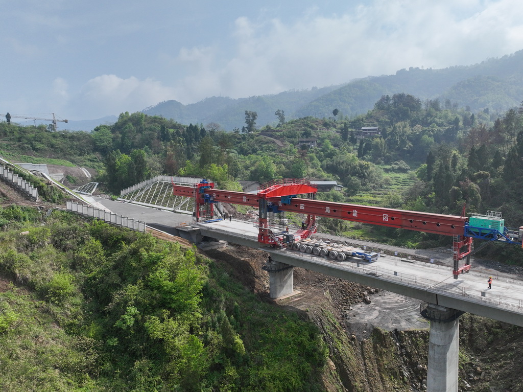 4月3日在四川省达州市拍摄的西渝高铁康渝段槽沟中桥架梁作业现场（无人机照片）。