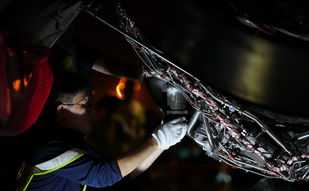 在海口美兰国际机场停机坪上，南航工程技术分公司机务工程师对“消博号”彩绘飞机进行深度检查（4月4日摄）。