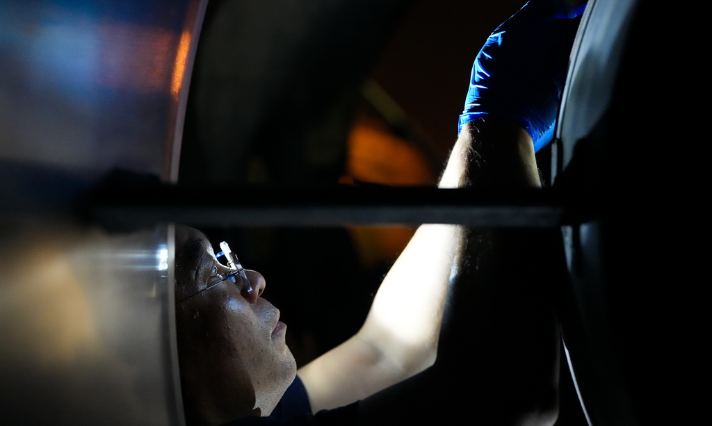 在海口美兰国际机场停机坪上,南航工程技术分公司机务工程师对“消博号”彩绘飞机进行深度检查(4月4日摄)。