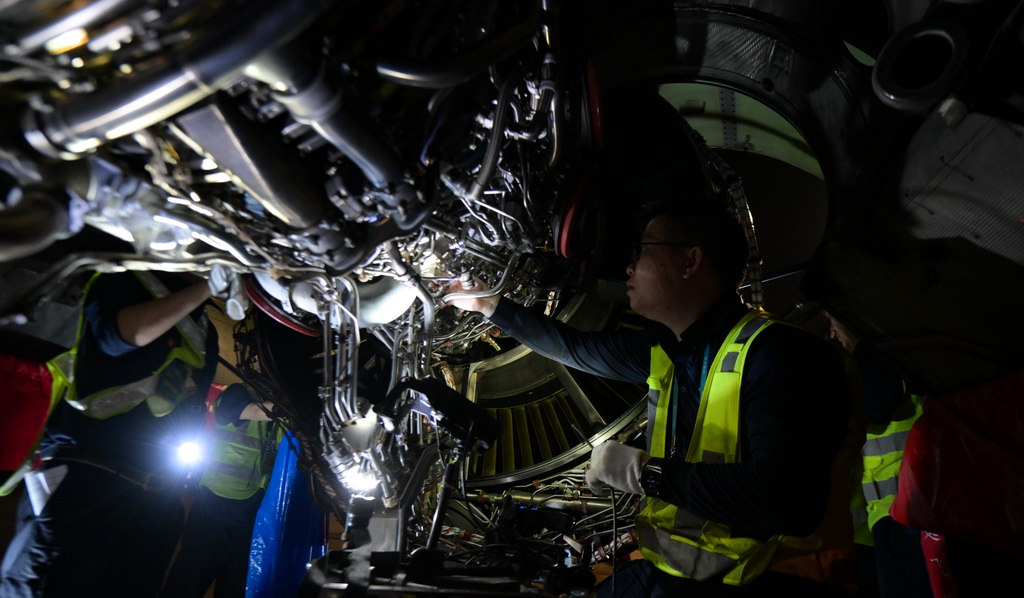 在海口美兰国际机场停机坪上，南航工程技术分公司机务工程师对“消博号”彩绘飞机进行深度检查（4月4日摄）。