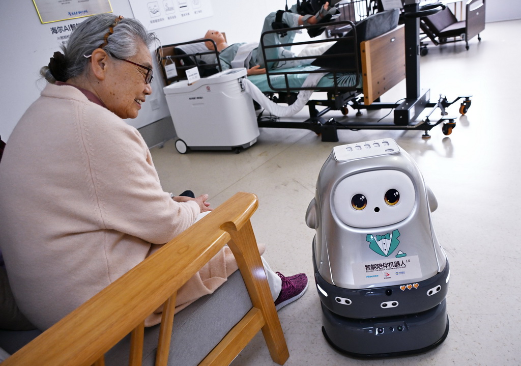 4月9日,在青岛市康养领域具身机器人暨智能康复类产品训练验证中心,老人在与智能陪伴机器人互动。