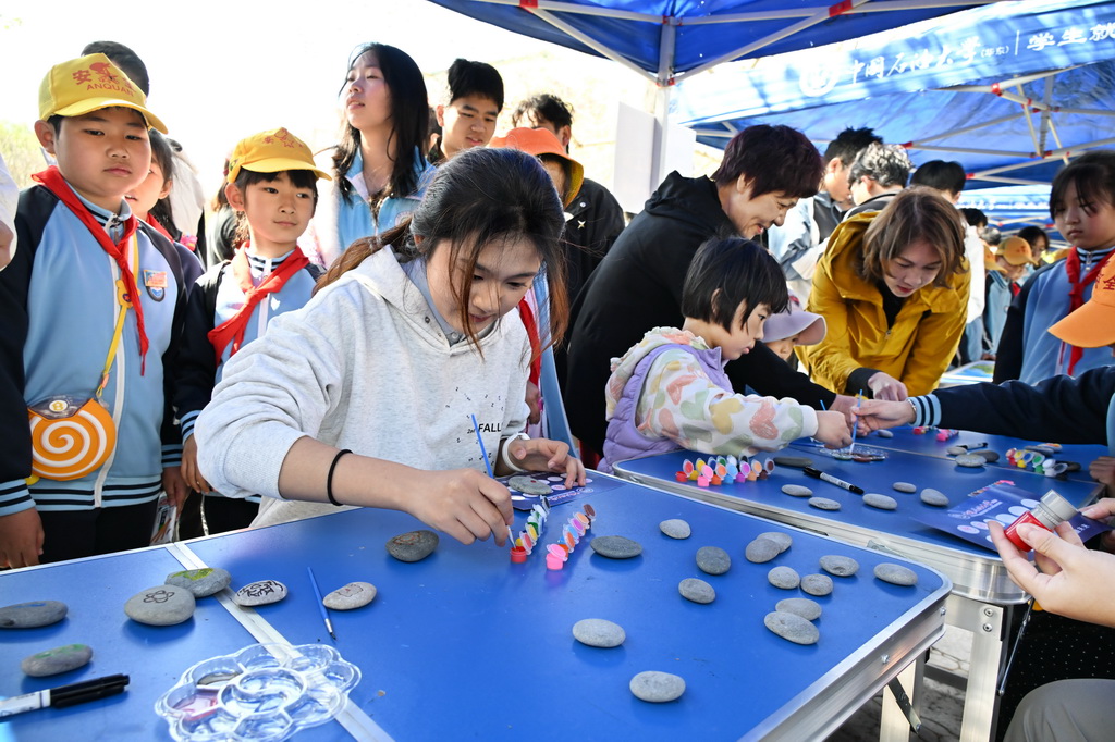 4月19日，游园参与者在地球科学文化游园会上绘制石头画。