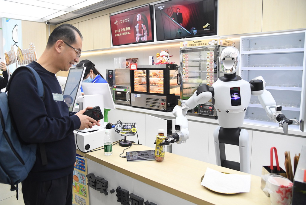 4月22日，在北京市海淀区中关村大街一座大厦内的便利店，机器人将抓取好的饮料交给顾客。