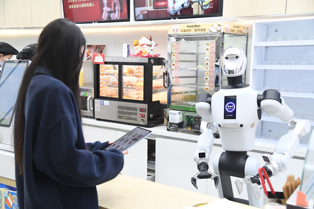 4月22日,在北京市海淀区中关村大街一座大厦内的便利店,顾客通过平板电脑下订单,机器人接收到订单后准备抓取货品。