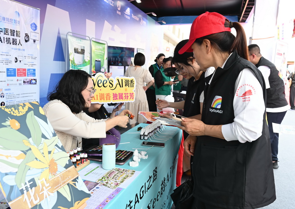 4月28日,OPC创业者(左)向参观者展示AI调香和AI精油。