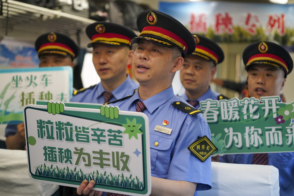 5月13日,乘务人员在K5153次“插秧专列”上为乘客表演文艺节目。