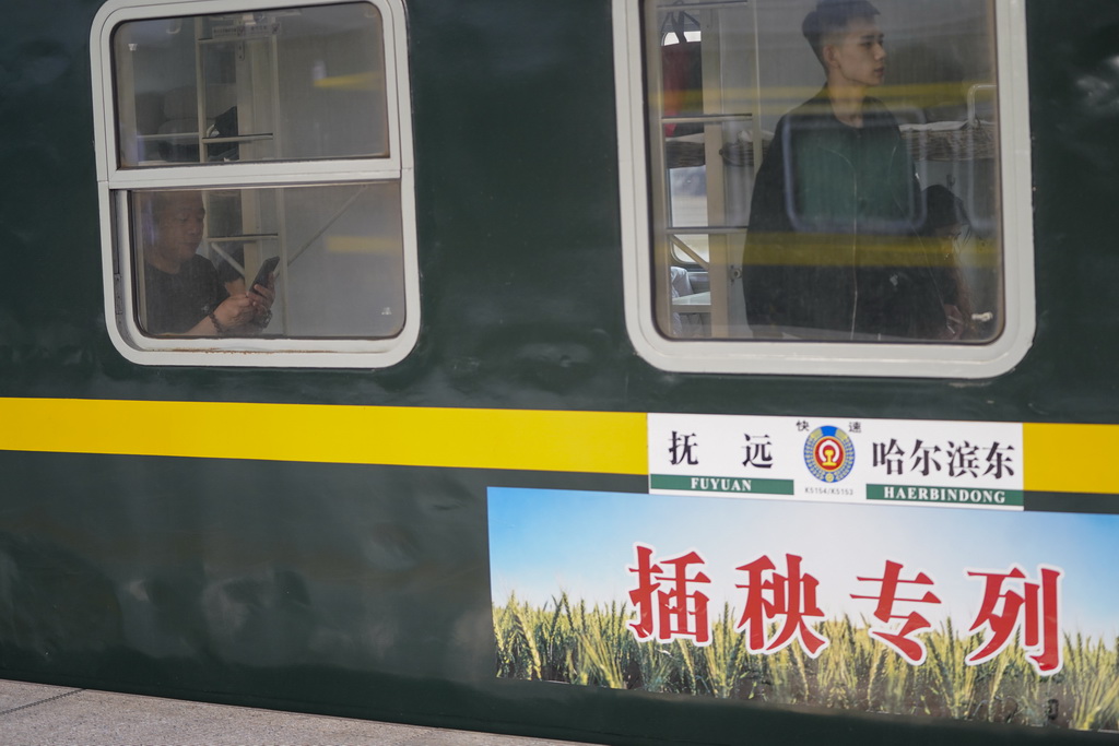 5月13日,乘客在哈尔滨东站搭乘K5153次“插秧专列”准备出行。
